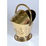 An Art Nouveau brass helmet shaped coal scuttle, swing handle, embossed with stylised flowers,