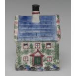 A South Yorkshire cottage money box, with blue titled roof, green and pink sponged gables,
