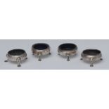 A composed set of four silver George III cauldron shaped salt cellars, hoof cabriole feet,