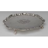 A George I silver shaped circular salver, piecrust border, crested field, wrapped knurl feet,