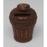 An early 19th century French cocquilla nut money box, the domed twist-top with a pierced coin slot,