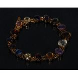 A multi gem bracelet, inset with sixteen assorted oval and round mixed cut gems including peridot,