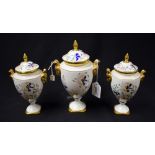 A trio of Coalport Pageant pattern pedestal urns and covers, each with ram mask handles,