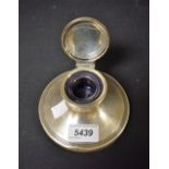 A silver capstan inkwell, hinged lid glass liner,