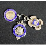 Three silver and enamel fobs;