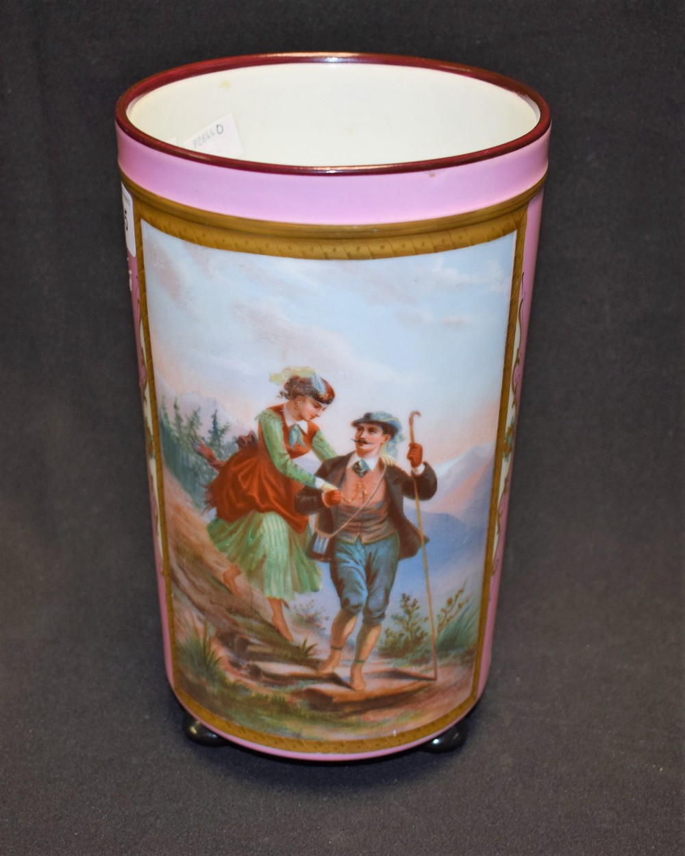 A 19th century German cylindrical vase, painted with Alpine couple on a rural path,