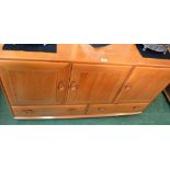 An Ercol Windsor sideboard, three cupboards over two long drawers,