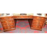 A Reprodux walnut veneer canted pedestal desk, tooled leather inlaid top,