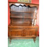 A Priory style oak dresser, two shelves and shaped uprights to top,