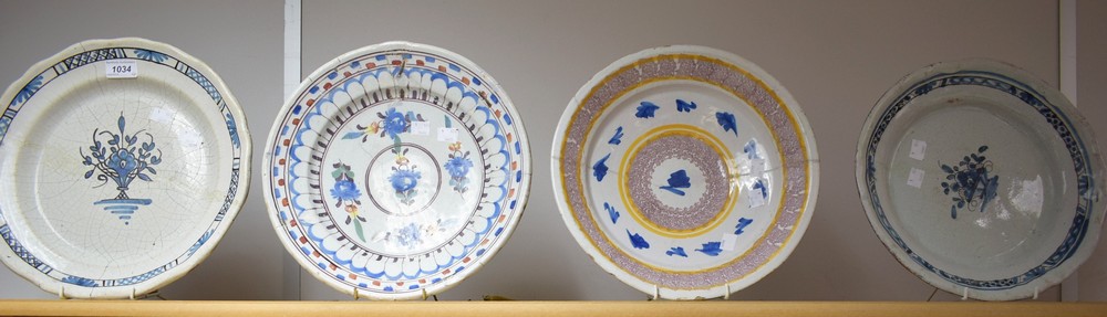 A 19th century Dutch shaped circular plate, decorated in blue with sylised vase of flowers,