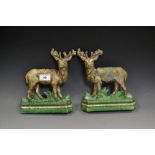 A pair of cast iron door stops, as Stags, standing to left and right,