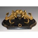 A 19th century lacquered brass maritime desk model, of a pair of anchors, shaped ebonised base,