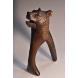 A Black Forest novelty lever-action nutcracker, carved as a bear, glass eyes, 20cm long,