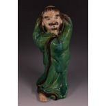 A Chinese terracotta figure, of a sagacious elder, he stands in flowing robes,