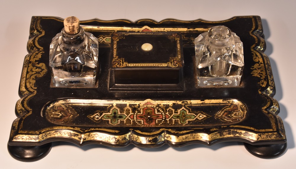 A Victorian papier mache shaped rectangular inkstand, glass wells divided by a wafer box,