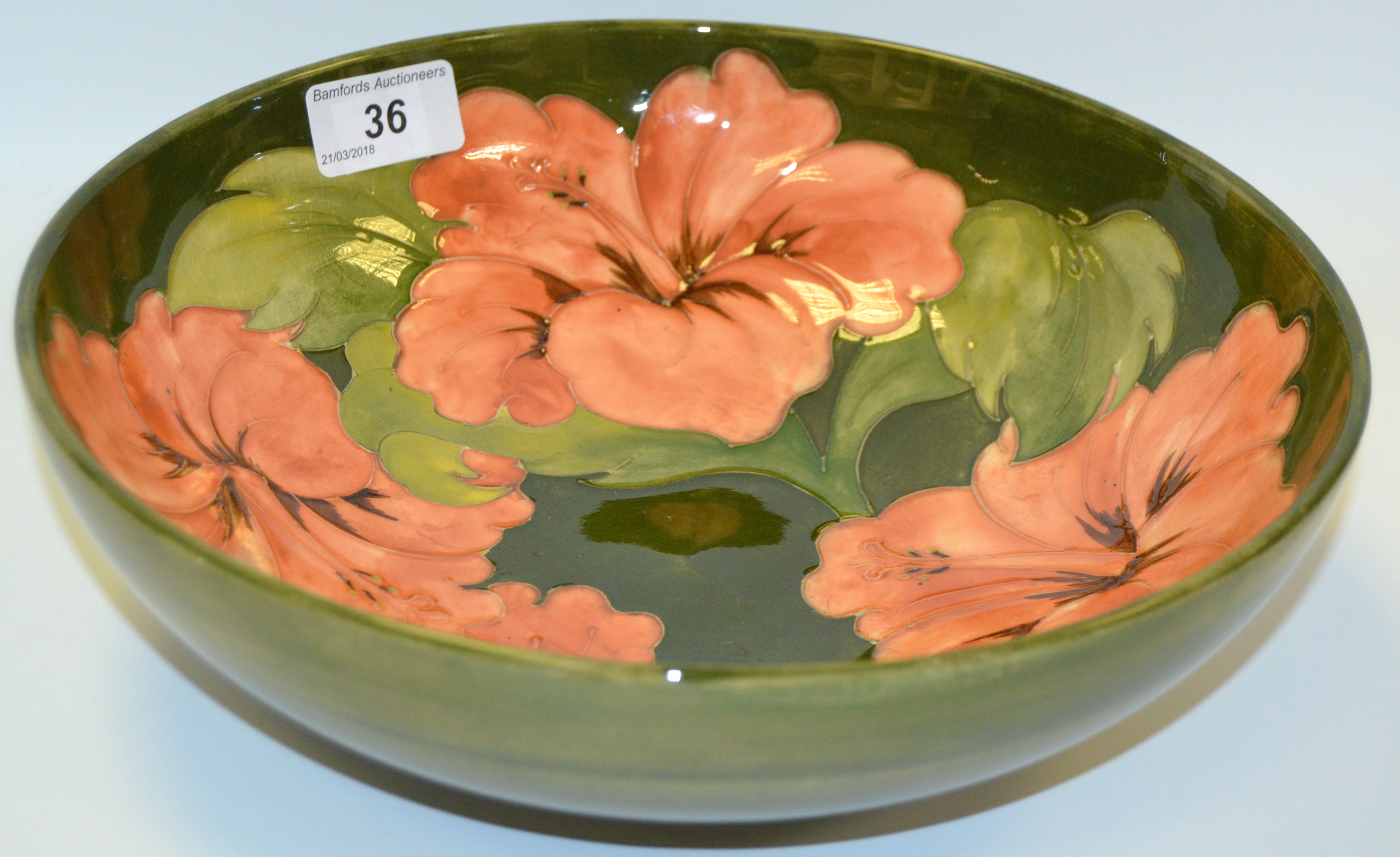 A Moorcroft Hibiscus pattern bowl tubelined on a green ground