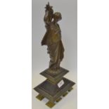 An early 20th century bronze figure of a Woman dressed in robes carrying a twin handled urn,