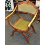 An early 20th Century oak X - frame chair, velvet upholstered seat,