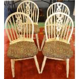 A set of four mid 20th century wheel back kitchen chairs painted cream