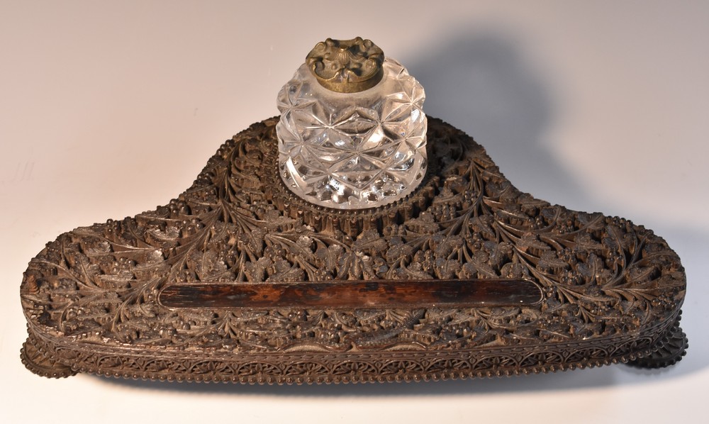 An Anglo-Indian hardwood inkstand, pierced and carved with dense scrolling foliage,