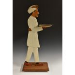 An Anglo-Indian 'blackamoor' coasting waiter, carved and painted as a turbaned attendant, he stands,
