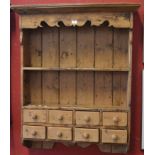 A pine country kitchen wall rack, outswept cornice, shaped frieze, two shelves over eight drawers,