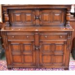 A Priory style oak court cupboard two door cupboard flanked ny turned columns to top, moulded top,