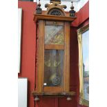 A walnut cased brass Vienna wall clock, eagle pediment, embossed brass face, Arabic numerals.