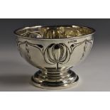 An Art Nouveau silver pedestal bowl, embossed with stylised flowers and sinuous swags,