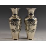 A pair of Chinese silver ovoid vases, each applied with a ferocious dragon, flared rim, 16cm high,