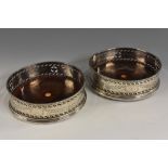 A pair of George III silver wine coasters,