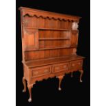 A George III design oak dresser, outswept cornice,