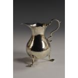 A George III silver bellied cream jug, wavy everted rim, capped double-scroll handle,