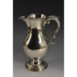 A George II silver baluster beer jug, acanthus-capped double scroll handle, raised circular foot,