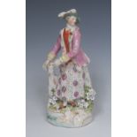 A Derby Patch Mark figure, Huntsman's companion, she stands wearing a pink jacket,