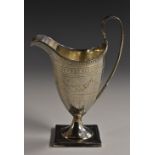 A George III silver helmet shaped cream jug, bright-cut engraved with swags and wriggle-work,