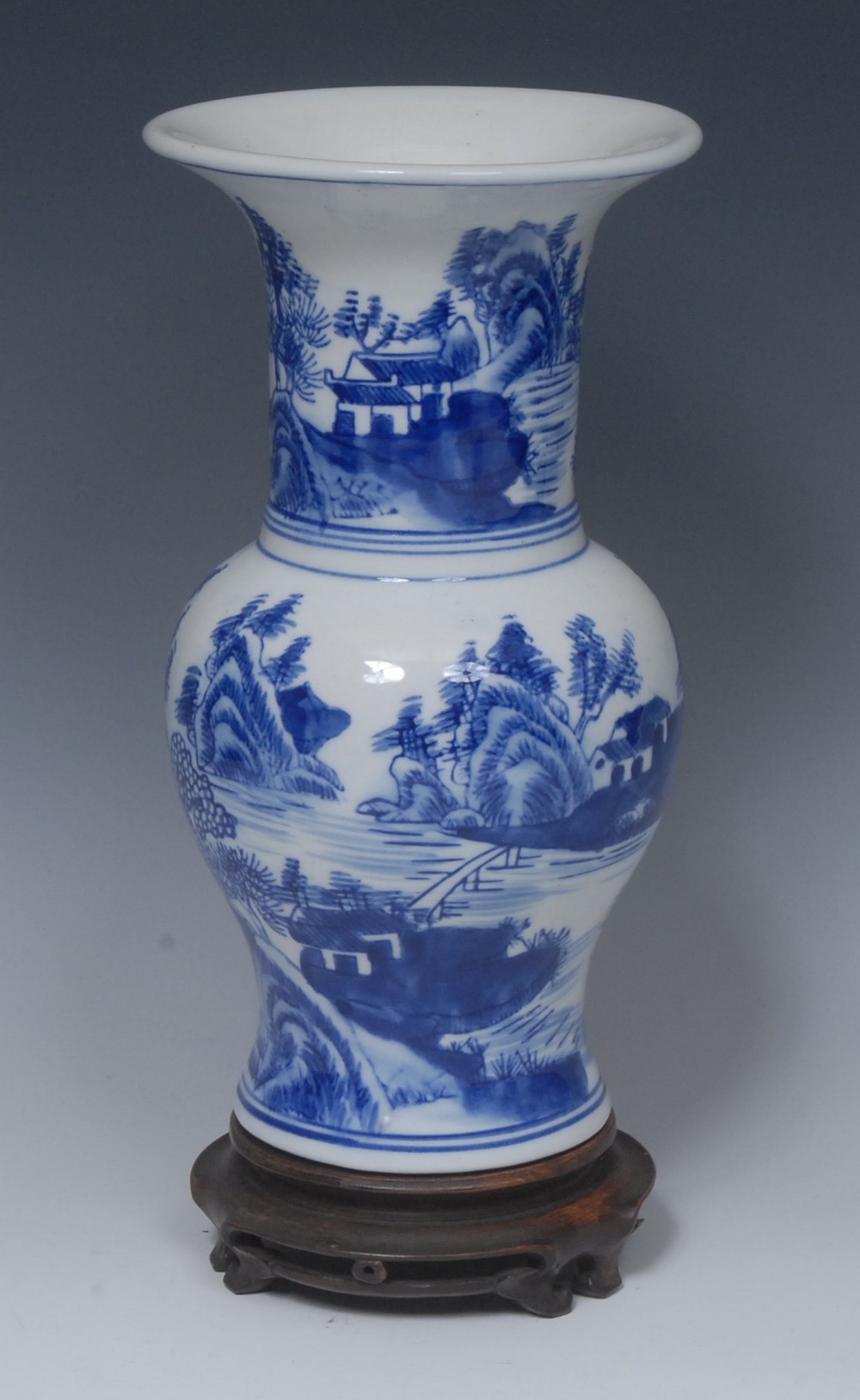 A Chinese gu shaped vase, painted in tones of underglaze blue with landscapes, 26.