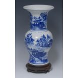 A Chinese gu shaped vase, painted in tones of underglaze blue with landscapes, 26.