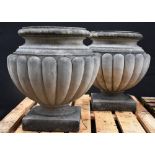 A pair of 19th century style composition fluted ovoid garden urns, square bases,