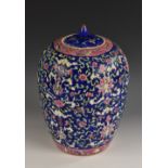 A Chinese ovoid jar and cover, brightly painted in polychrome with flowers and scrolling leaves,