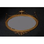 An Empire style gilt oval mirror,