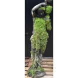 An early 19th Coade stone type garden statue, as a Bacchic maide, she stands,