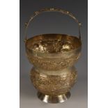 An Indian silver vase, chased with buildings in a landscape, on a textured ground, arched handle,