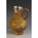 A 16th/17th century silver mounted brown salt glazed stoneware bellarmine jug, mottled tiger glaze,