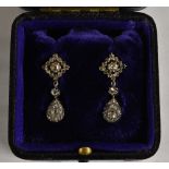 A pair of diamond drop earrings, each set with twenty seven round, pear and rough cut diamonds,