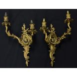 A pair of Rococo Revival ormolu two-branch wall sconces, cast throughout with scrolling acanthus,