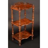 A Victorian walnut three-tier whatnot, pierced three-quarter gallery, serpentine plateaux,