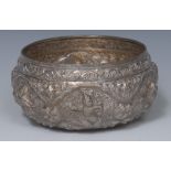 A Burnese silver bowl, typically chased with deities amongst scrolling foliage, 14cm diam, c.