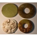 A Chinese jade circular disc, the centre carved with yin and yang with radiating flutes, 7.