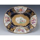 A Chelsea shaped oval dish, painted with a fanciful birds, within a leafy gilt cartouche,